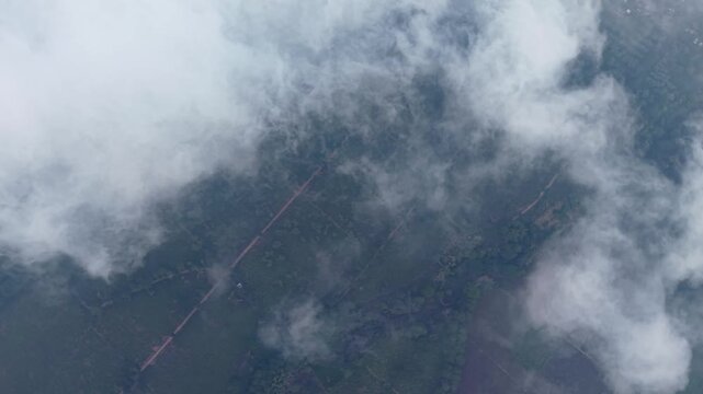 Drone shot flying above rustic dirt pathways and tourist tracks cutting through the lush green fields of Wonosari tea agrotourism area