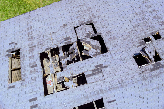 Roof several holes missing shingles damaged wood plywood after tornado