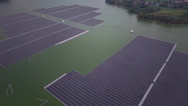 Floating solar panels stretch across calm green water at Waduk Karangkates