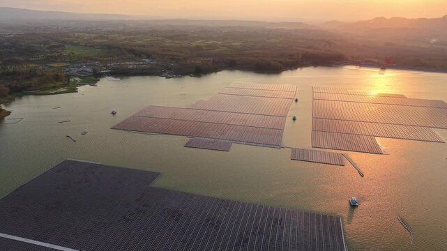 Floating solar panels glide across calm lake waters. Sunset hues reflect off panels at East Java