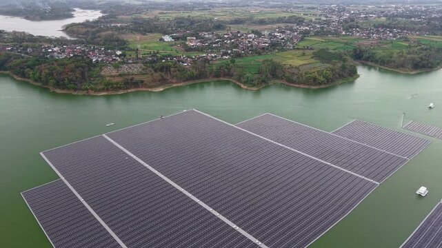 Floating solar panels stretch across calm green waters at Waduk Karangkates