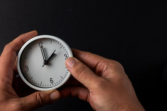 Hands Adjusting Clock for Time Change