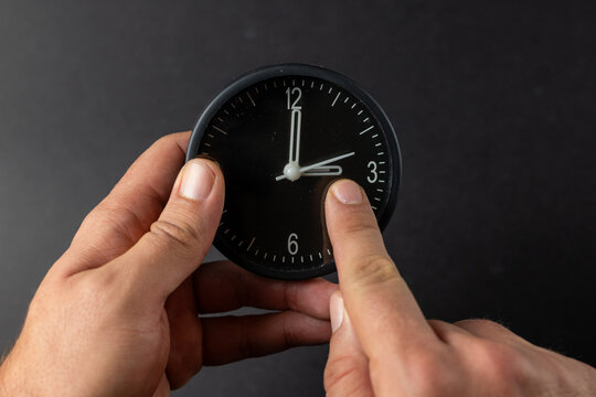Hands Adjusting Clock for Time Change