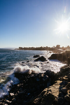 Pacific ocean waves crashing against rocky shoreline along West Cliff Drive in Santa Cruz California