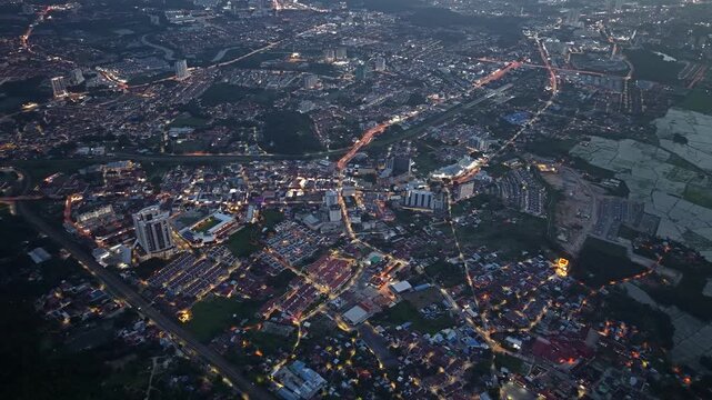 Aerial view of an urban area at dusk showing illuminated buildings and roads forming a complex network of lights at Bukit Mertajam