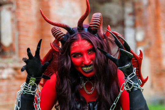 Scary Red Demon Woman with Horns and Wings in Halloween Costume