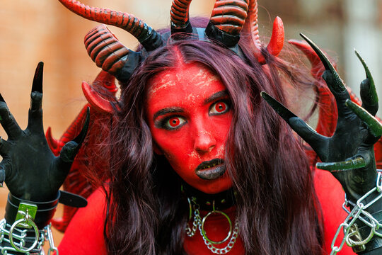 Scary Red Demon Woman with Horns and Wings in Halloween Costume