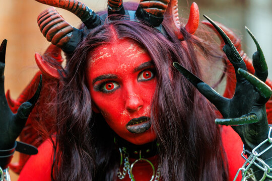 Scary Red Demon Woman with Horns and Wings in Halloween Costume