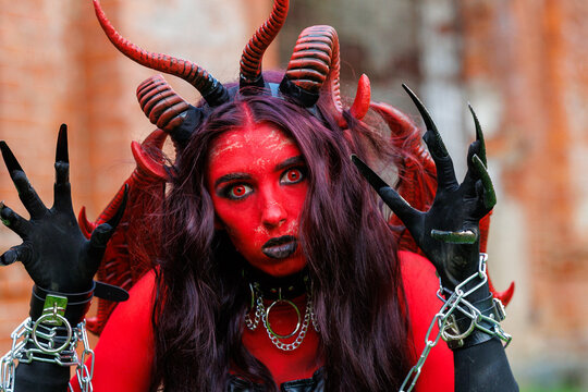 Scary Red Demon Woman with Horns and Wings in Halloween Costume