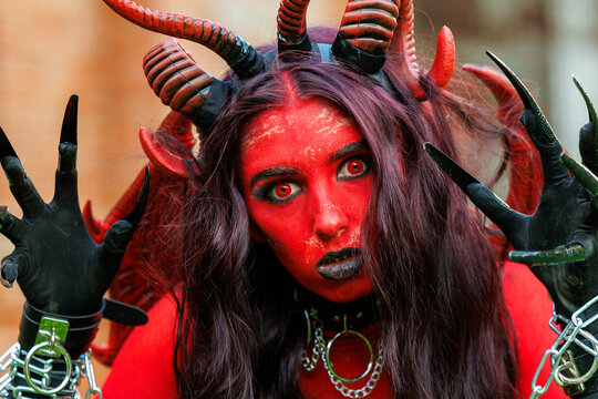 Scary Red Demon Woman with Horns and Wings in Halloween Costume