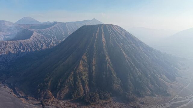 Aerial view of Gunung Batok eroded volcanic slopes, ash plains, and surrounding caldera mountains in Indonesia.