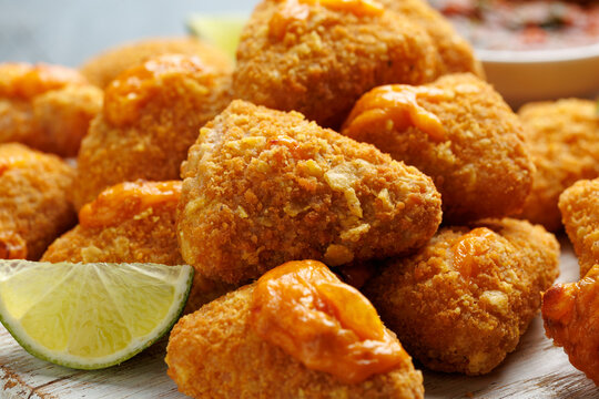 Crispy Nacho Cheese Bites with Dipping Sauce and Lime Wedges