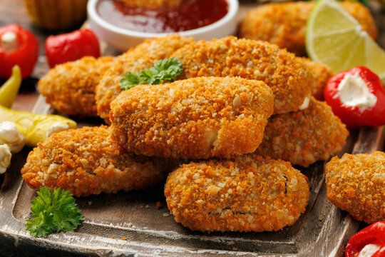 Crispy baked cream cheese stuffed jalapeno poppers with lime wedges and sweet chili sauce