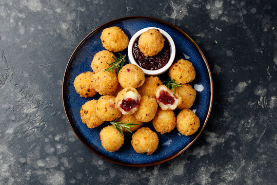 Party appetizers with brie cheese, cranberry sauce and fresh rosemary on crackers, served on plate