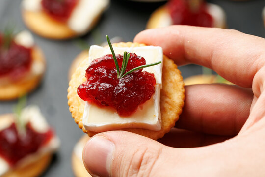 Party appetizers with brie cheese, cranberry sauce and fresh rosemary on crackers