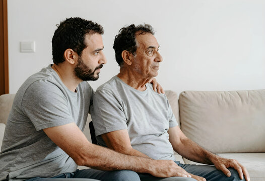Caregiving and family support, adult son comforting senior father at home with emotional connection and compassion during difficult times