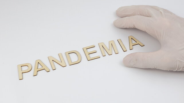 The single word PANDEMIA (pandemic) written in Italian on wood. A healthcare-related concept, featuring a hand and copy space