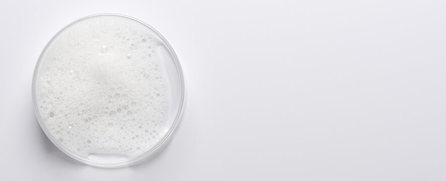 Soap foam in a Petri dish. Facial cleanser. Copy space