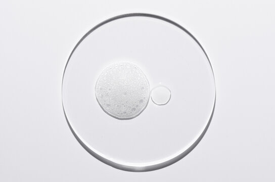 A sample of a cosmetic cleansing product in the form of foam. On a glass circle.