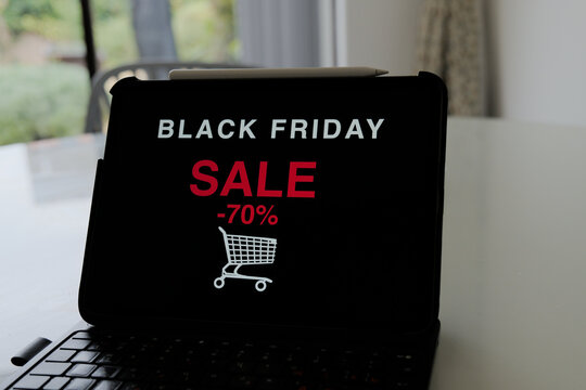 Tablet screen displaying black friday sale announcement on dark display screen on desk