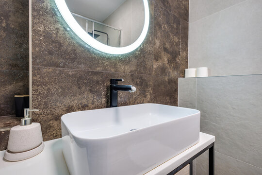  details of corner with water tap sink with faucet with soap and shampoo dispensers in expensive bathroom in rustic eco style