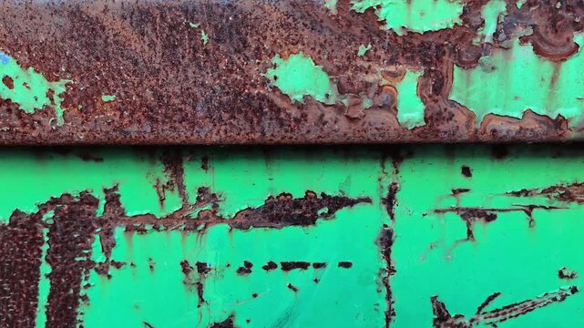 Close up of weathered green metal sheet with rust and peeling paint for industrial textures, grunge backgrounds, and abstract surface concepts.