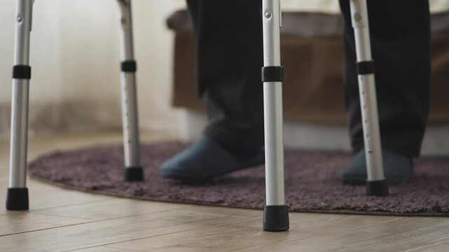 Close-up of elderly man with disability using walking frame, learning to move