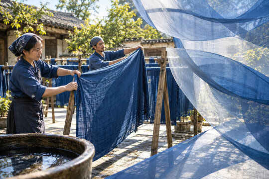 Artisans drying indigo cloth outdoors