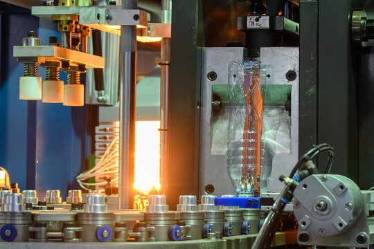 PET bottles mass production operation coming out of a blow molding machine