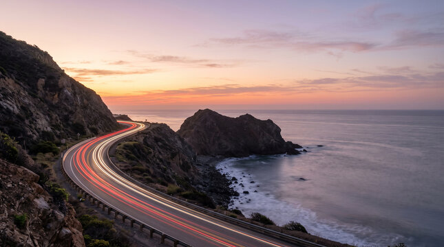 Coastal Highway at Sunset With Red and White Light Trails Above Calm Ocean, Long Exposure Seascape