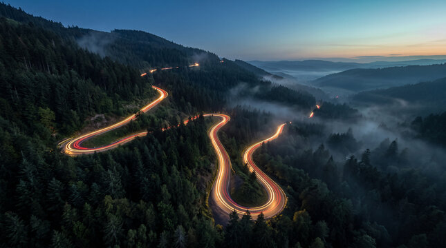 Aerial View of Winding Mountain Road With Golden Light Trails at Blue Hour, Serpentine Hairpin Curves