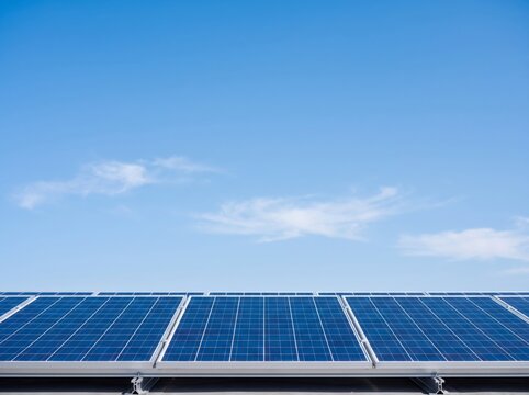 Solar panel array installed on rooftop against clear blue sky with copy space