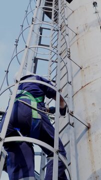 Engineers wearing harness safety climbing up the chimney to check and measure carbon dioxide levels or for air pollution reduction, continues emission monitoring system. Sustainable Environment. ESG