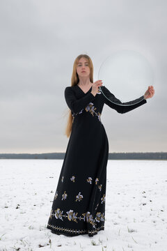 art portrait of young woman in vintage dress in snow white winter landscape