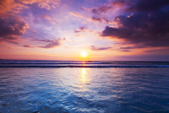 Beautiful sunset over the tropical beach with purple sky