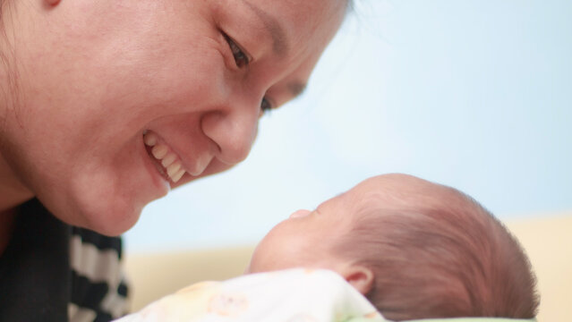 Maternal love, bonding, intimacy and family tenderness. Close up of a mother gazing affectionately at her newborn baby, highlighting their face to face connection in soft natural light.