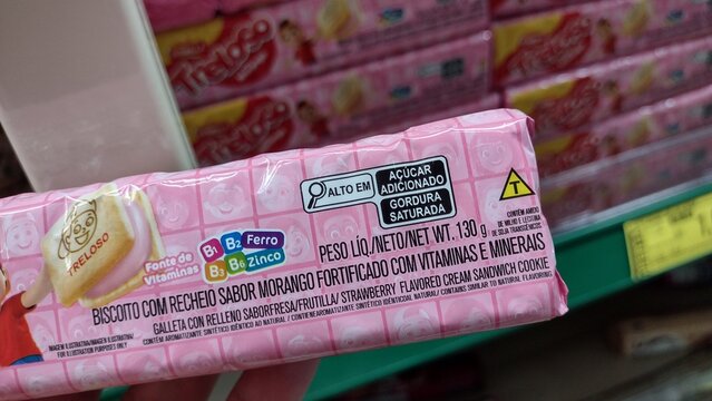 ITABIRA, BRAZIL - OCTOBER 19, 2026: Treloso strawberry sandwich cookie package highlighting fortified vitamins B1 B2 B3 B6 iron zinc claims and nutritional warnings on shelf