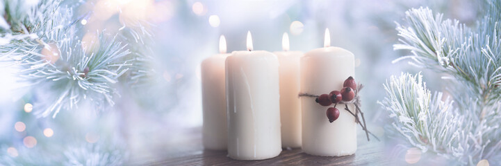 Four glowing candles in glittering winter atmosphere with soft bokeh. Festive outdoor decoration for christmas greetings and seasonal celebrations.  © gudrun