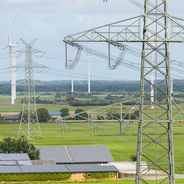 Strommast einer Hochspannungsleitung mit Windpark in Nordfriesland
