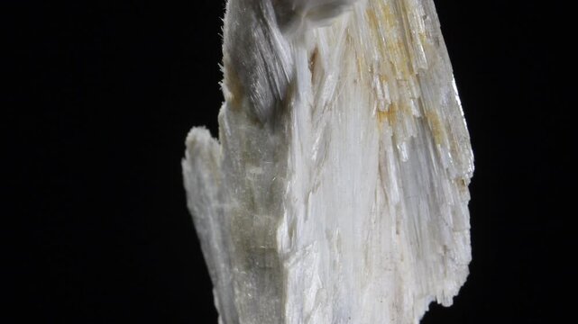 Wollastonite - calcium inosilicate mineral - crystals rotating against a black background