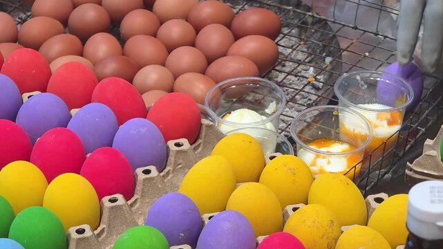 Colorful preserved eggs in cartons and soft boiled eggs in plastic cups at Thailand street food market stall
