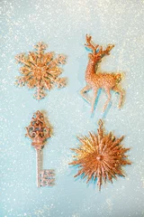 Accurate rows of four golden beautiful sparkling christmas decoration on pastel blue background. Festive concept. © Anna Efetova