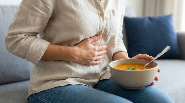 Woman suffering from bloating and abdominal pain while eating