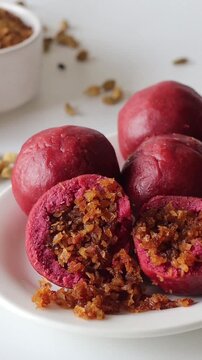 Beetroot kozhukatta with coconut jaggery filling cut open to show the sweet centre