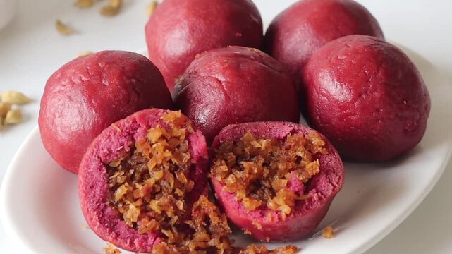 Beetroot kozhukatta with coconut jaggery filling cut open to show the sweet centre