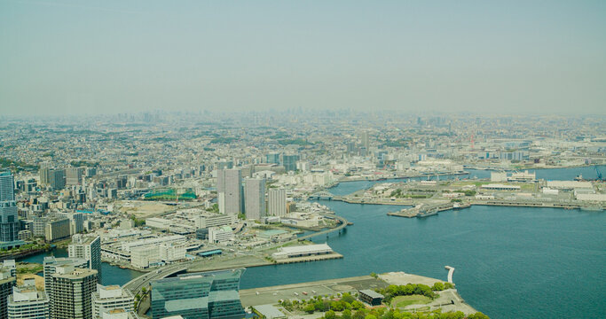 Yokohama, Japan - 22 April 2025: View of Minato Mirai district featuring modern skyscrapers, waterfront piers, and urban infrastructure along the bay.