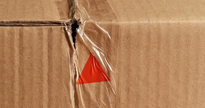 Damaged cardboard box sealed with warning tape