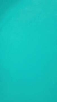 Close up view of clean ocean surfing wave barrel curling with white foam in clear blue sea. Perfect background for surfing, water sports, and extreme adventure. Vertical video