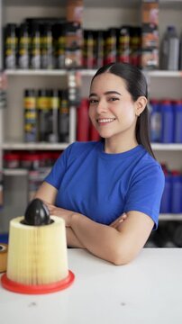 Female auto mechanic presenting car air filter in auto parts store
