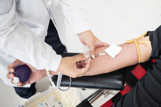 Selective focus hand of doctor inject blood from donor arm into bag while donating blood at blood bank unit in hospital.Donation for emergency surgery at donation center.Save life and medical concept.